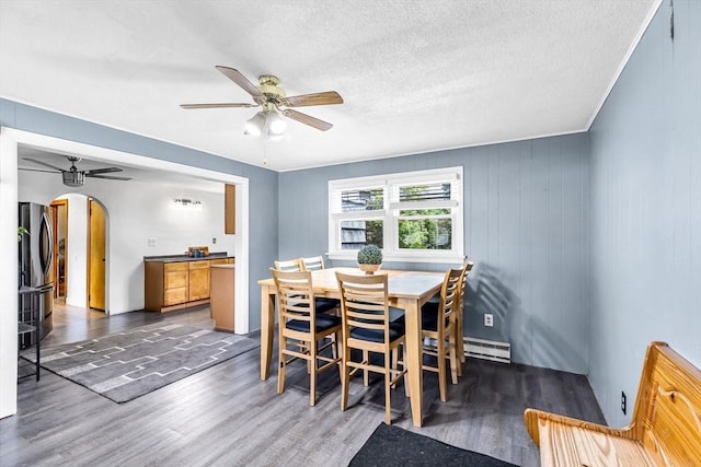 59 Kulig St, Springfield, MA 01104 - dining area with arched walkways, wood finished floors, a ceiling fan, baseboard heating, and a textured ceiling