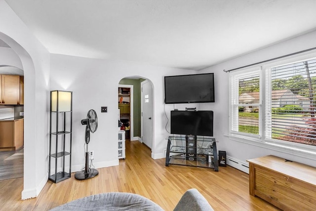 59 Kulig St, Springfield, MA 01104 - living area featuring arched walkways, baseboard heating, light wood-type flooring, and baseboards