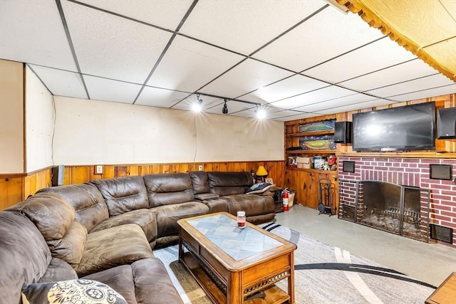 59 Kulig St, Springfield, MA 01104 - living room featuring wood walls, finished concrete floors, rail lighting, a paneled ceiling, and a wainscoted wall