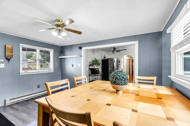 59 Kulig St, Springfield, MA 01104 - dining area featuring a ceiling fan, arched walkways, wood finished floors, baseboard heating, and a textured ceiling