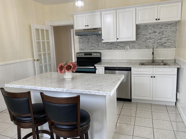 49 Euclid Ave, Springfield, MA 01108 - kitchen with stainless steel dishwasher, a sink, electric range, under cabinet range hood, and light tile patterned floors