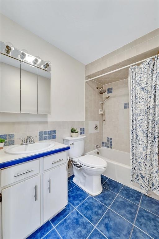 131 Beacon St Unit 4, Chelsea, MA 02150 - full bathroom with toilet, vanity, tile patterned floors, tile walls, and shower / tub combo with curtain