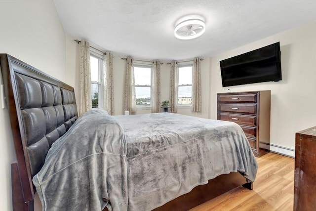 131 Beacon St Unit 4, Chelsea, MA 02150 - bedroom with a baseboard heating unit, light wood finished floors, and multiple windows