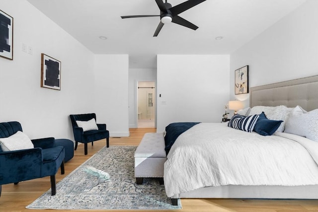 bedroom featuring hardwood / wood-style floors, ceiling fan, and ensuite bathroom