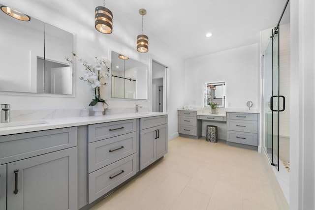 bathroom featuring a shower with door and vanity