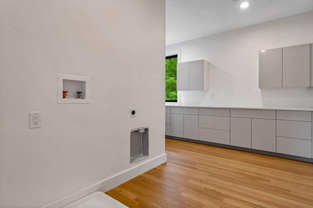 washroom with light wood-type flooring, cabinets, hookup for a washing machine, and electric dryer hookup