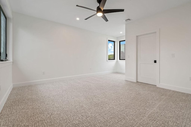 spare room featuring light carpet and ceiling fan