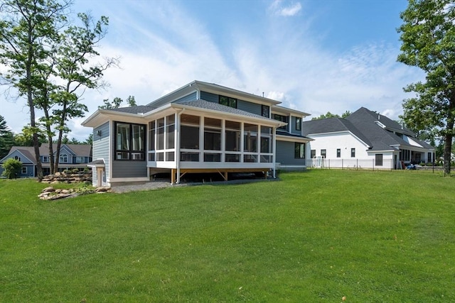 rear view of house with a yard and a sunroom