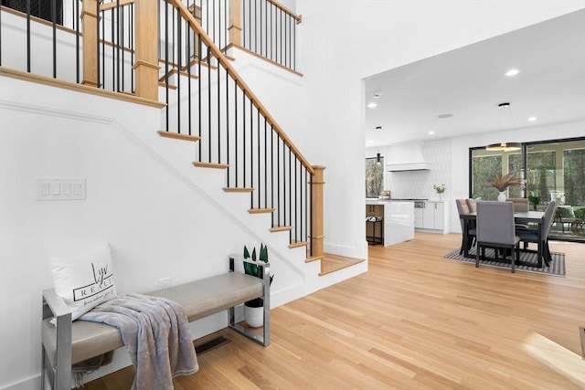 stairway with a high ceiling and wood-type flooring