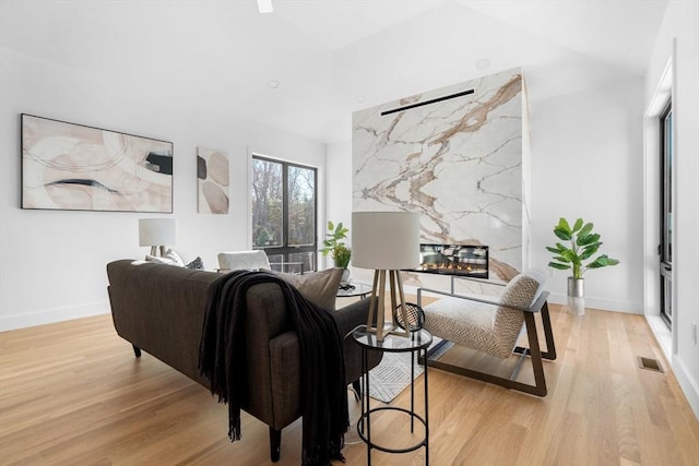 living room featuring light hardwood / wood-style flooring and a fireplace