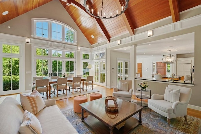 sunroom / solarium with wood ceiling, french doors, an inviting chandelier, and vaulted ceiling with beams