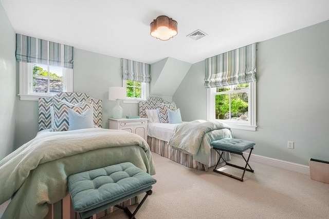 carpeted bedroom featuring lofted ceiling, baseboards, and visible vents