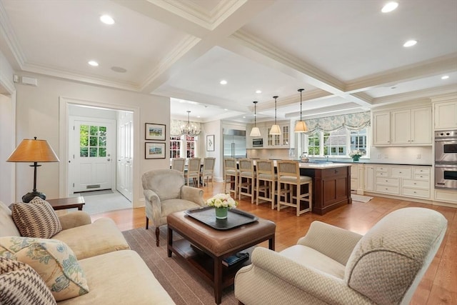 living area with beam ceiling, light wood-style flooring, a healthy amount of sunlight, and coffered ceiling