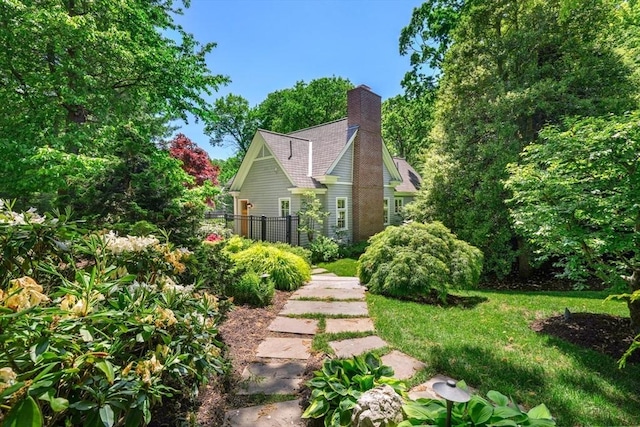 exterior space with a chimney, a front yard, and fence