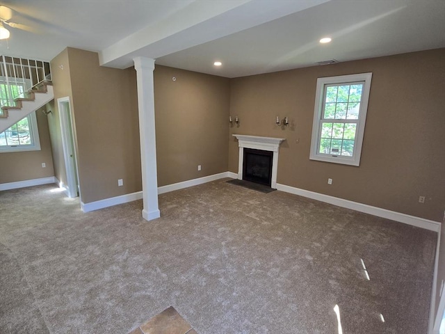 unfurnished living room with carpet floors, a ceiling fan, stairs, baseboards, and a fireplace with flush hearth