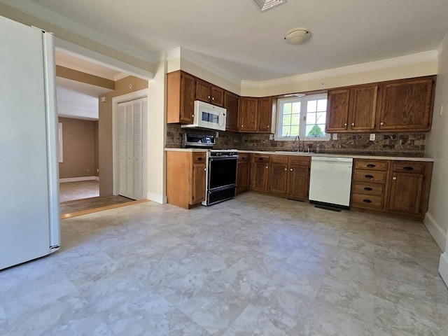 kitchen with white appliances, ornamental molding, a sink, and tasteful backsplash