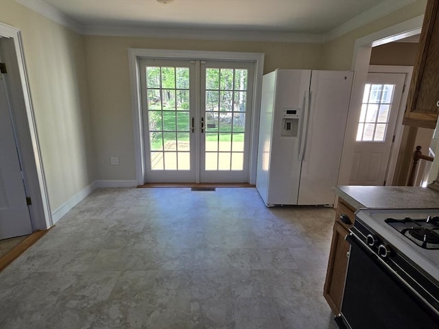kitchen featuring plenty of natural light, white fridge with ice dispenser, range with gas stovetop, and french doors