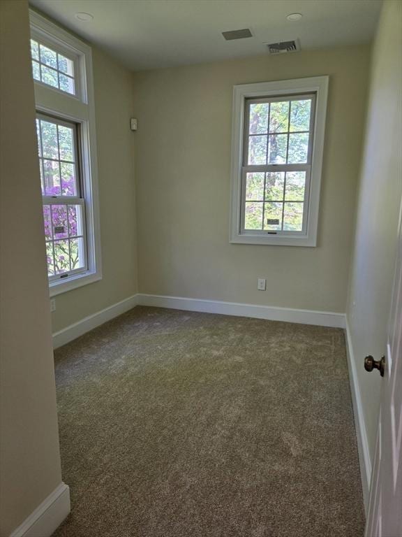 spare room with baseboards, visible vents, and carpet