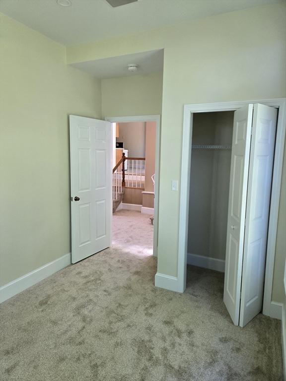 unfurnished bedroom featuring a closet, carpet flooring, and baseboards