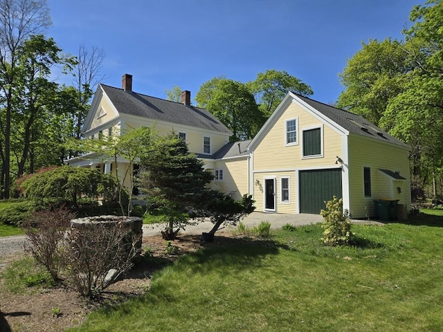 back of house featuring a lawn and a chimney