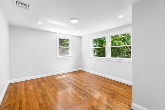 empty room with recessed lighting, visible vents, baseboards, and wood finished floors