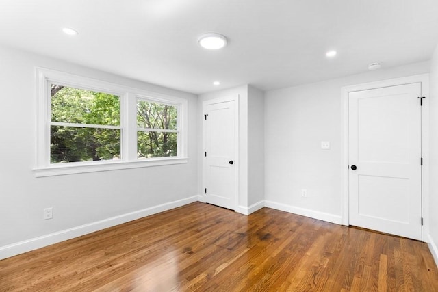 spare room featuring wood finished floors, baseboards, and recessed lighting
