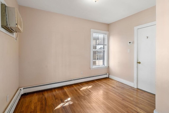 113 Belmont St, Belmont, MA 02478 - empty room with a baseboard radiator, an AC wall unit, light wood-style floors, and baseboards