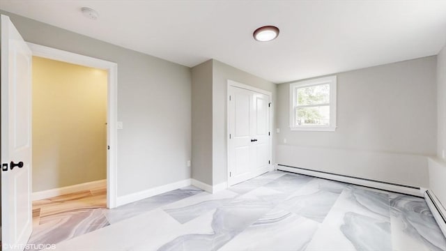 bedroom with baseboard heating and a closet