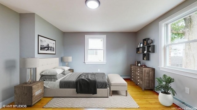 bedroom featuring baseboard heating and light hardwood / wood-style floors