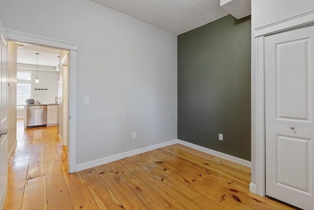 interior space featuring light wood-type flooring and baseboards