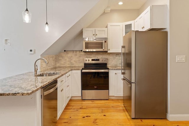 kitchen with a sink, appliances with stainless steel finishes, a peninsula, and white cabinets