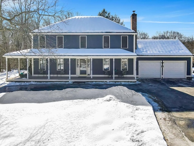 view of front of home featuring aphalt driveway, covered porch, a chimney, and an attached garage