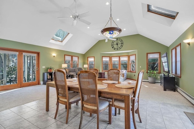 dining space with a skylight, light tile patterned floors, light carpet, high vaulted ceiling, and baseboards