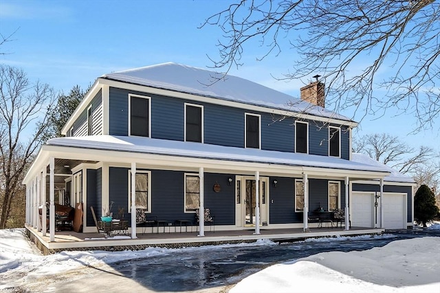 view of front facade with a garage, a porch, and a chimney