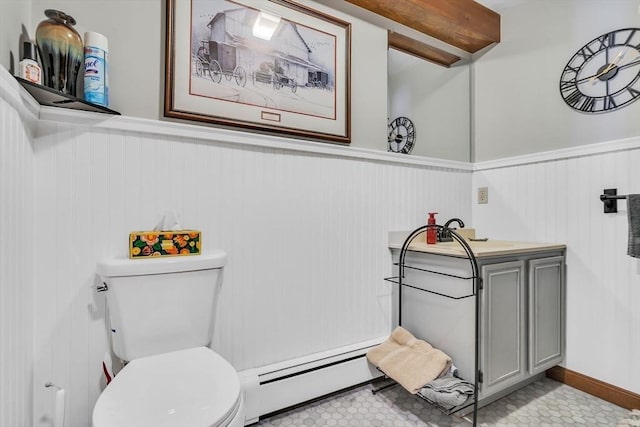 bathroom featuring a baseboard heating unit, a wainscoted wall, and toilet