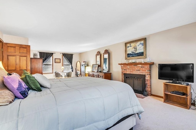 bedroom with a fireplace, baseboards, and carpet flooring