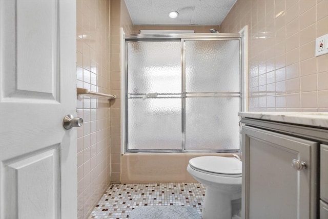 24-26 Lincoln St, North Andover, MA 01845 - bathroom featuring tile walls, vanity, tile patterned floors, enclosed tub / shower combo, and a textured ceiling