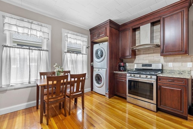 24-26 Lincoln St, North Andover, MA 01845 - kitchen featuring stainless steel gas stove, stacked washer / drying machine, backsplash, light wood-style flooring, and light stone countertops