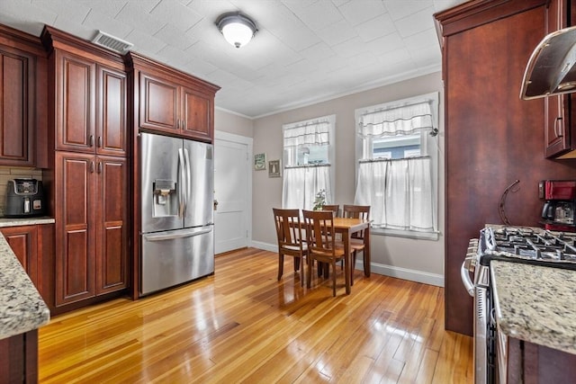 24-26 Lincoln St, North Andover, MA 01845 - kitchen featuring appliances with stainless steel finishes, light wood-type flooring, crown molding, dark brown cabinets, and light stone counters
