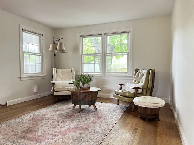 living area featuring hardwood / wood-style flooring and baseboards