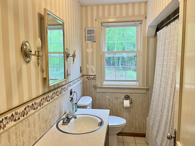 bathroom with wallpapered walls, tile patterned floors, toilet, a wainscoted wall, and vanity