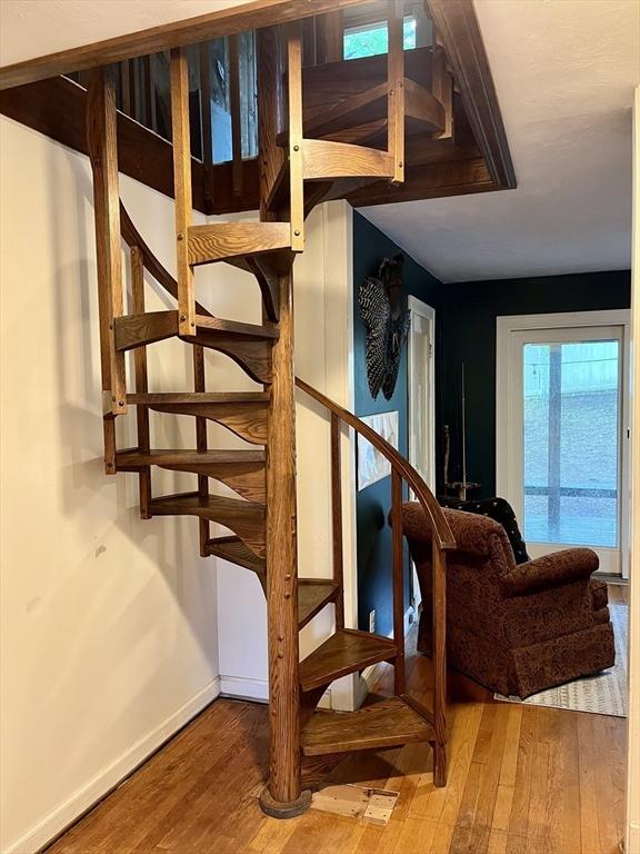 staircase with hardwood / wood-style flooring and baseboards