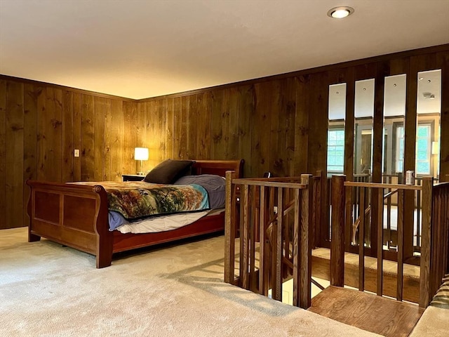 bedroom featuring carpet flooring and wooden walls