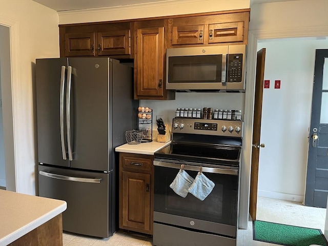 kitchen with appliances with stainless steel finishes, light countertops, and light tile patterned floors