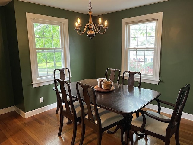 dining space featuring a chandelier, healthy amount of natural light, and dark wood-style flooring