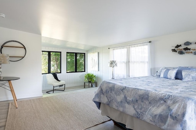 bedroom featuring multiple windows, french doors, vaulted ceiling, and hardwood / wood-style flooring