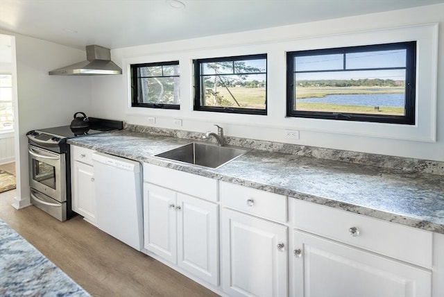 kitchen with white dishwasher, sink, wall chimney range hood, white cabinets, and stainless steel electric range oven