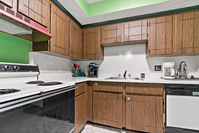 kitchen with brown cabinets, light countertops, a sink, white appliances, and under cabinet range hood