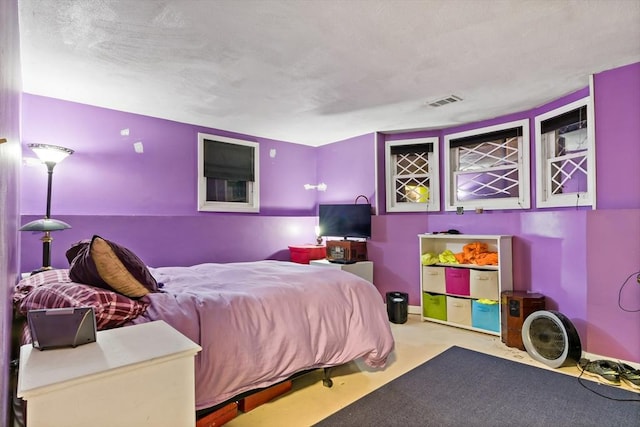 carpeted bedroom with visible vents, a textured ceiling, and baseboards