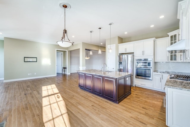 kitchen featuring appliances with stainless steel finishes, decorative light fixtures, light hardwood / wood-style floors, and white cabinets